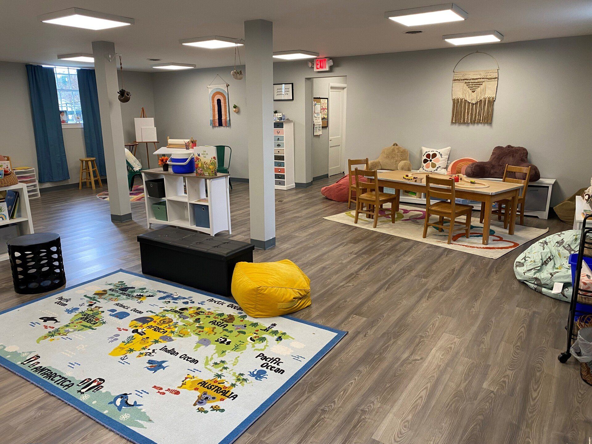 A large room with a map on the floor and tables and chairs.