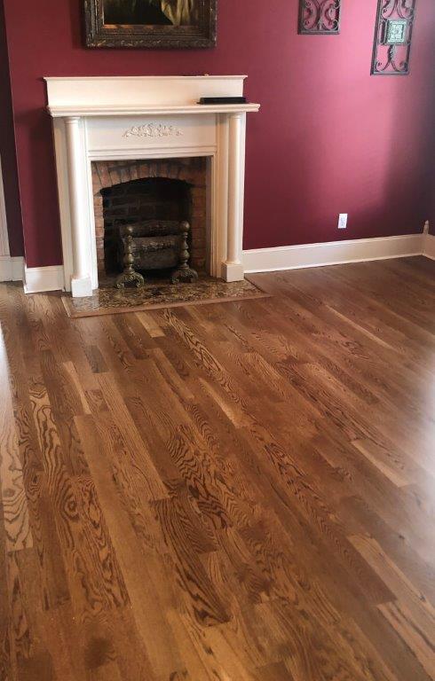A living room with hardwood floors and a fireplace.