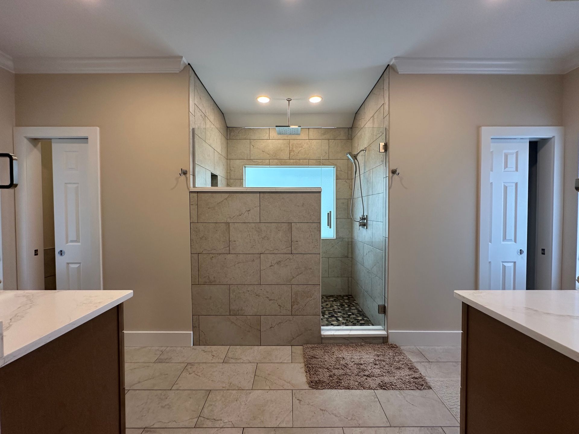 A bathroom with two sinks and a walk in shower