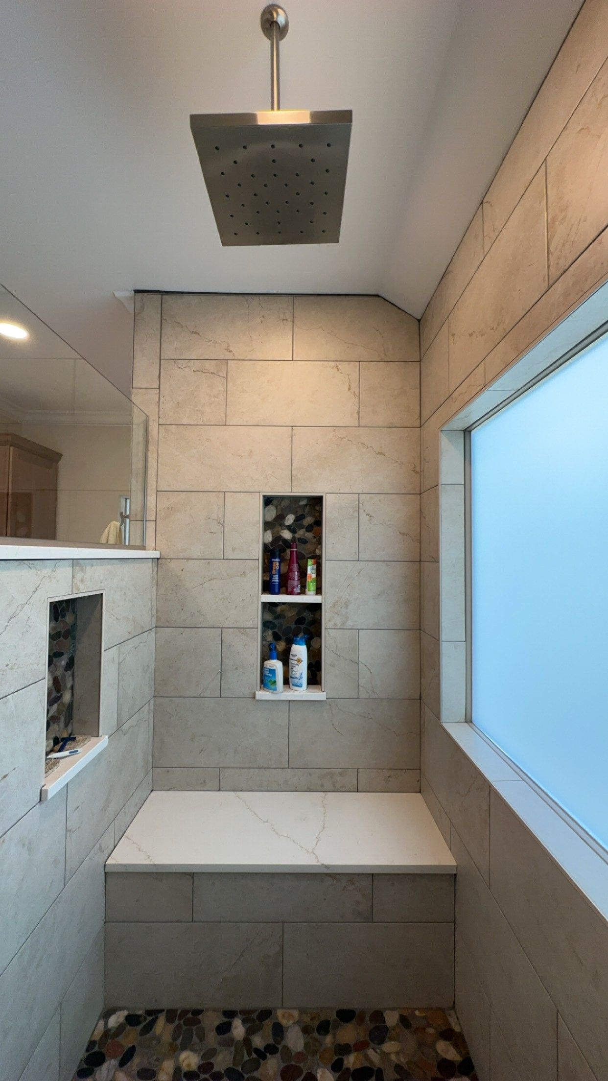 A bathroom with a shower head and a window.