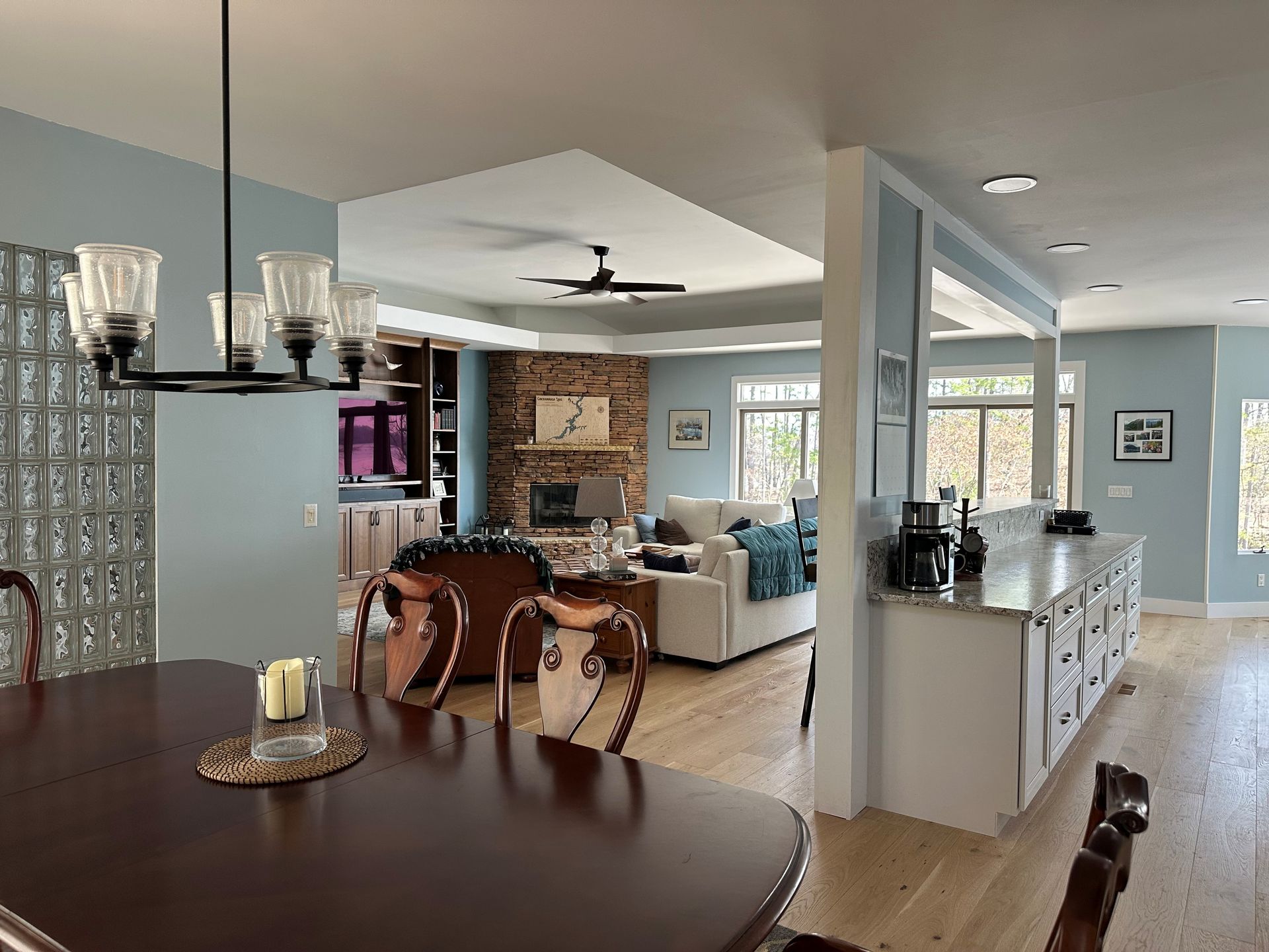A living room with a table and chairs and a ceiling fan