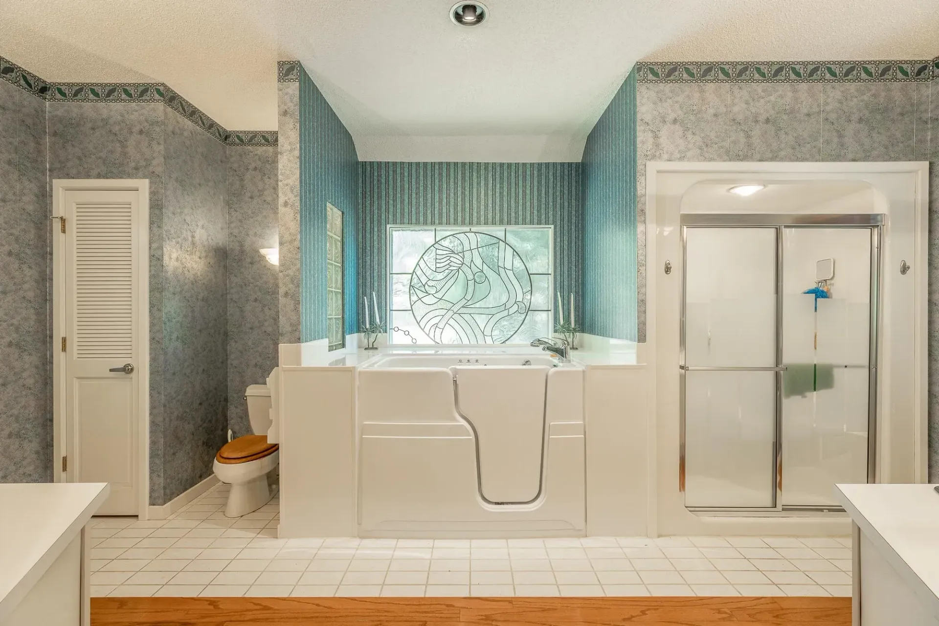 A bathroom with a walk in tub , toilet , and shower.
