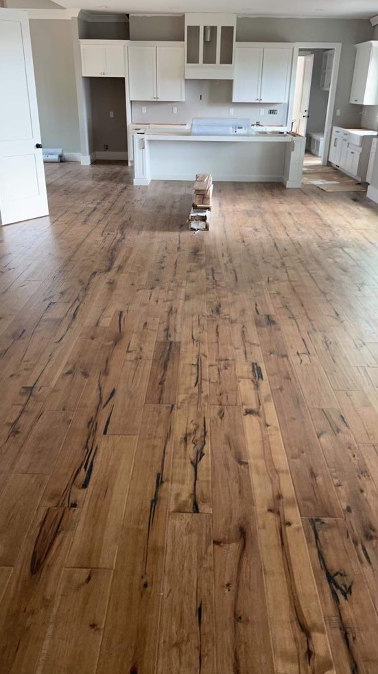A kitchen with a wooden floor and white cabinets.