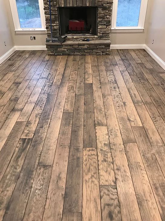 A living room with a wooden floor and a fireplace.