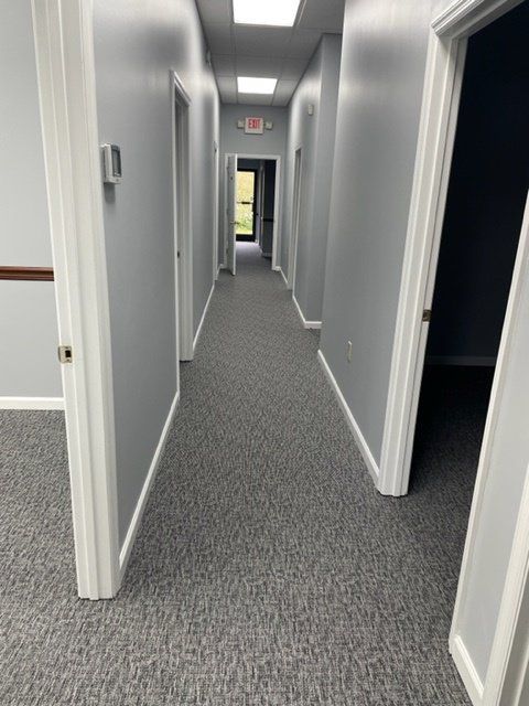 A long hallway with gray carpet and white walls
