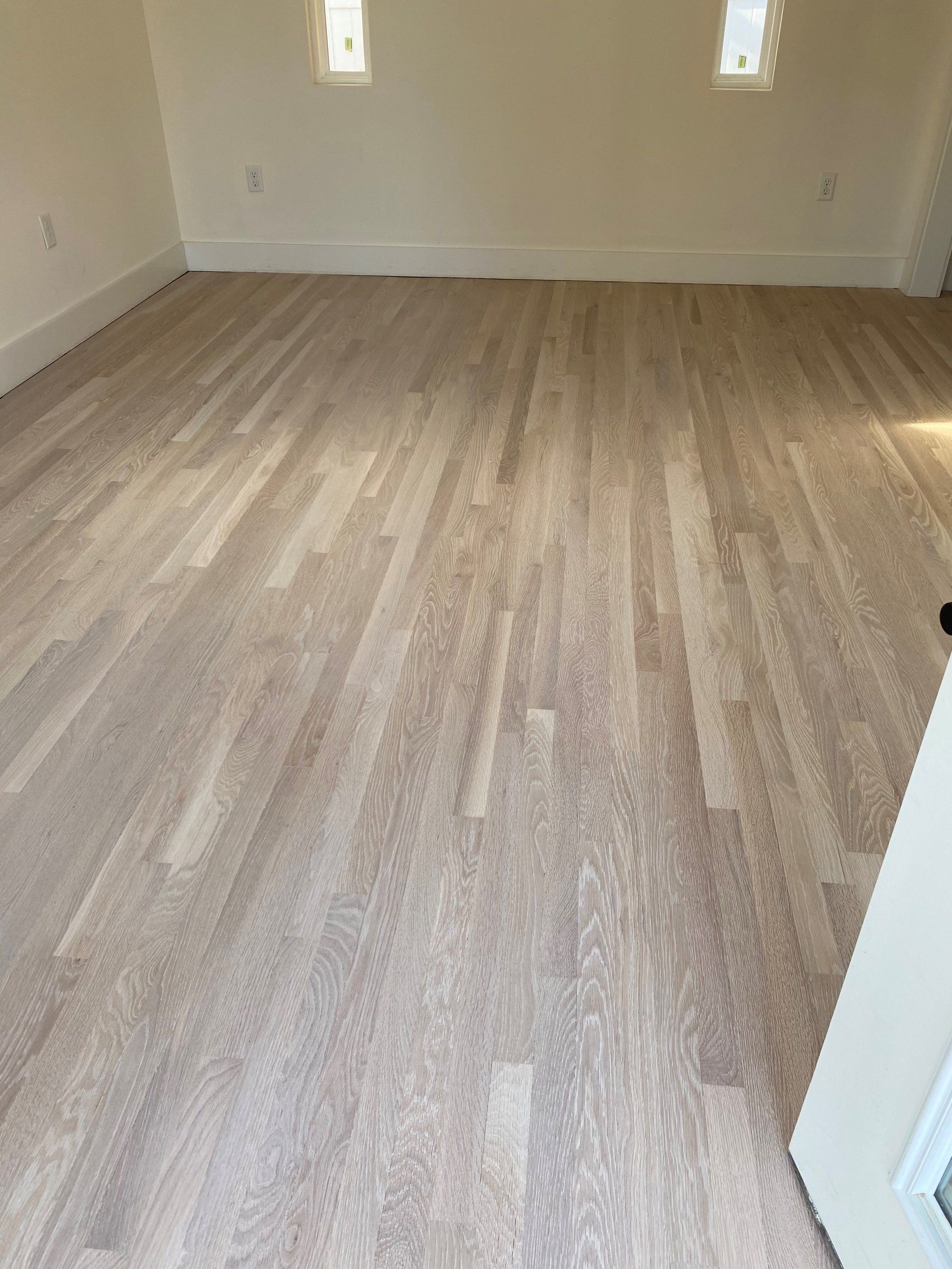 A room with a wooden floor and white walls.