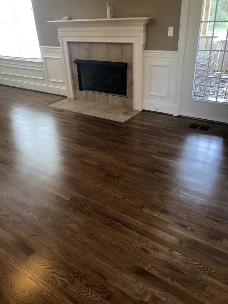 A living room with hardwood floors and a fireplace.