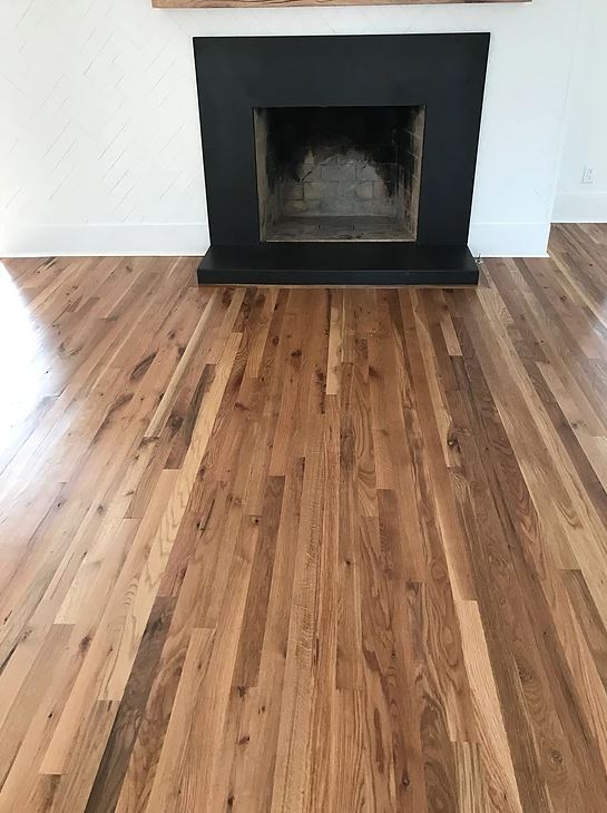 A living room with hardwood floors and a fireplace.