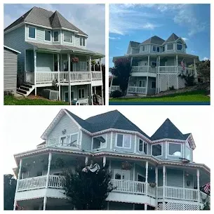 Three-story pale blue house with wrap-around porch, several dormers, and dark gray roof.