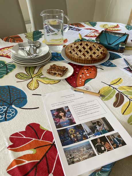 A table with plates , a pie and a piece of paper on it.