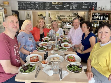 A group of people are sitting at a table with plates of food.