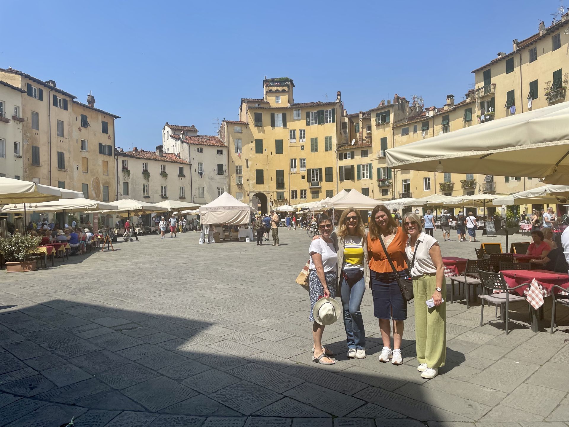 A group of women are posing for a picture in a city square.