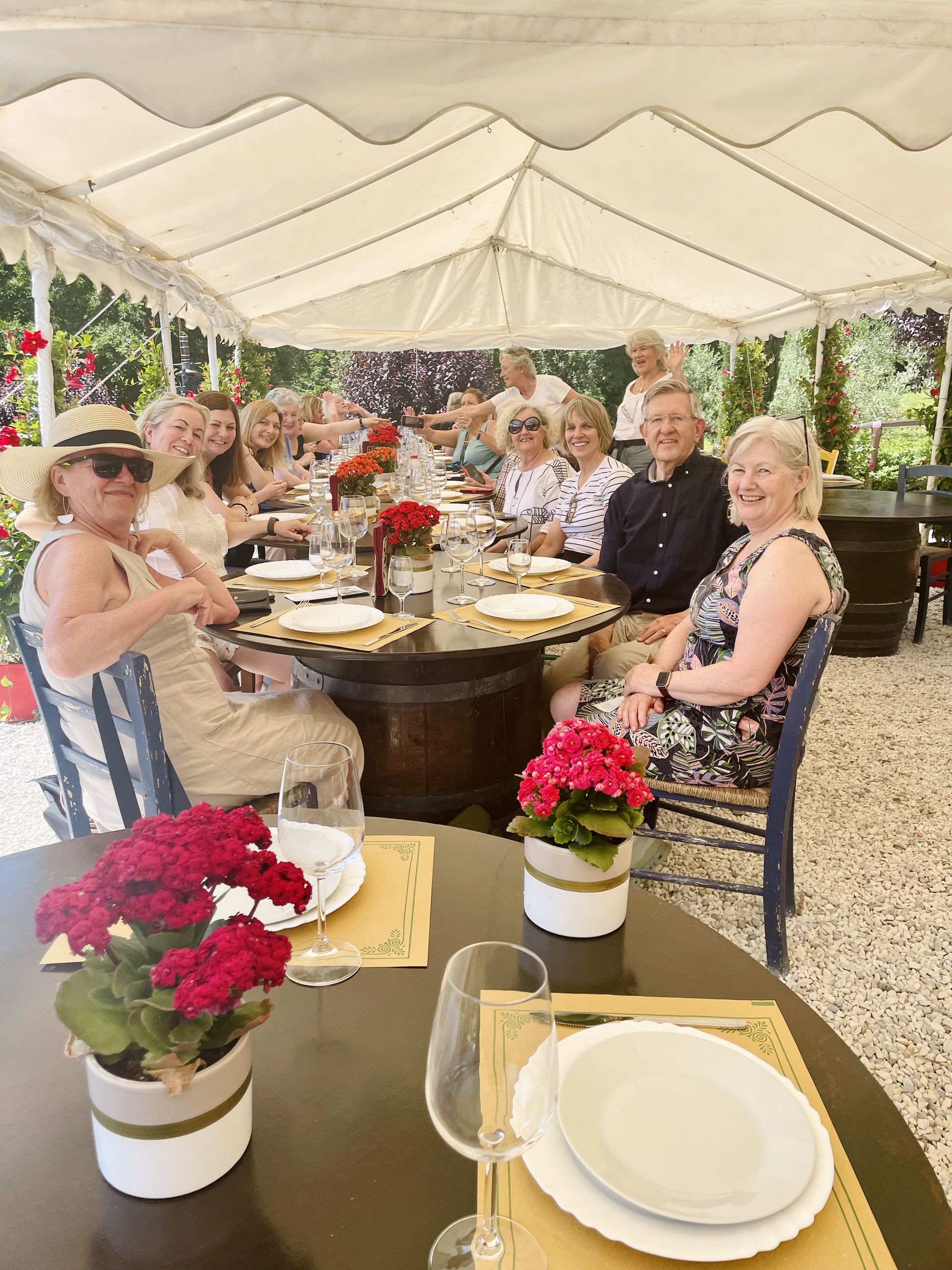 A group of people are sitting at a table under a tent.
