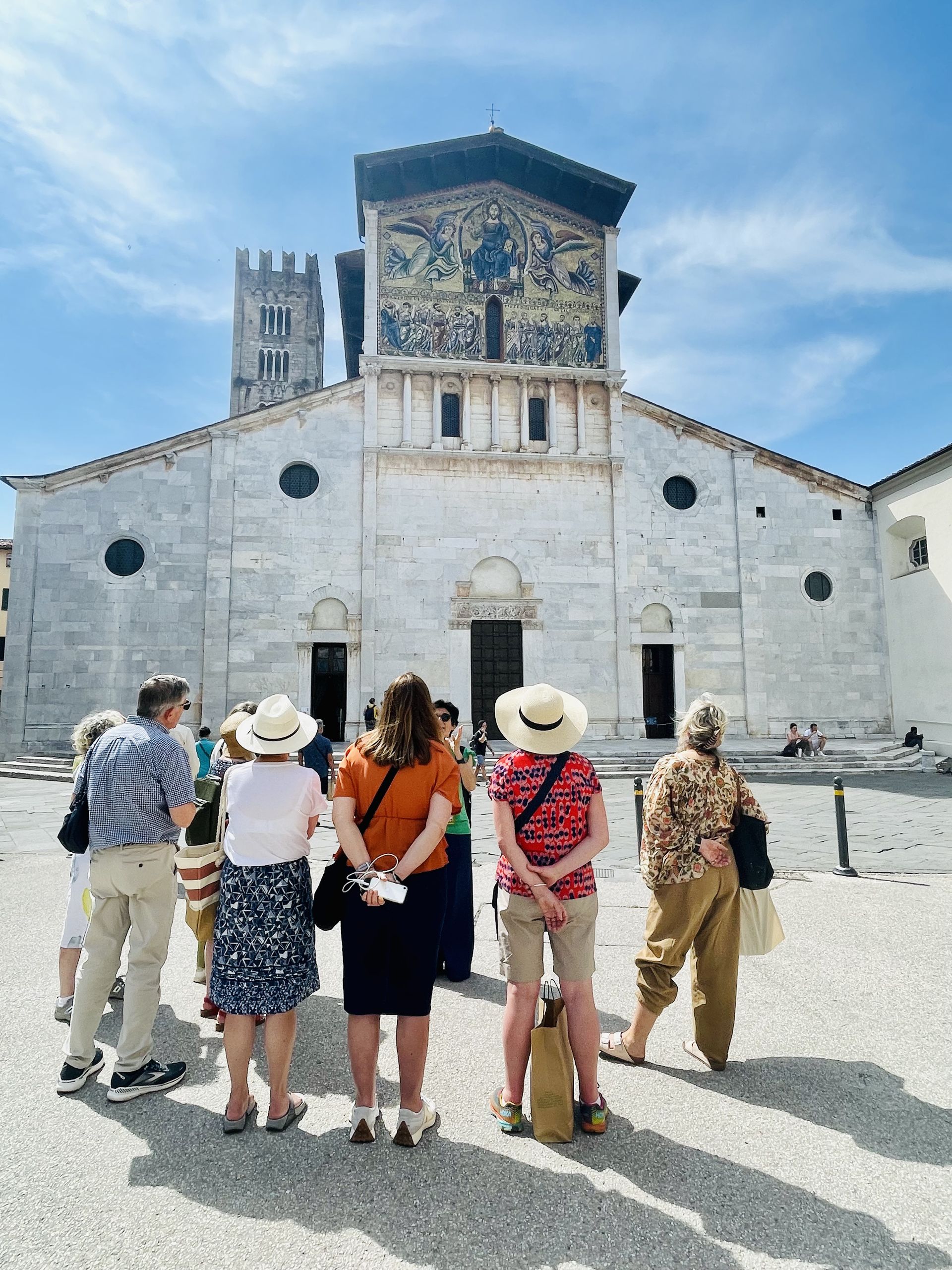 A group of people are standing in front of a large building.