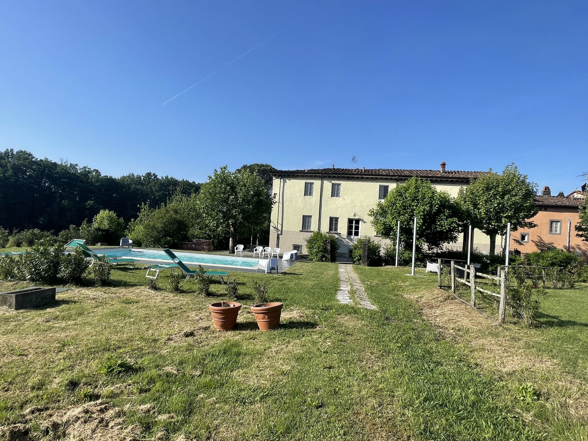 There is a large house with a swimming pool in the backyard.