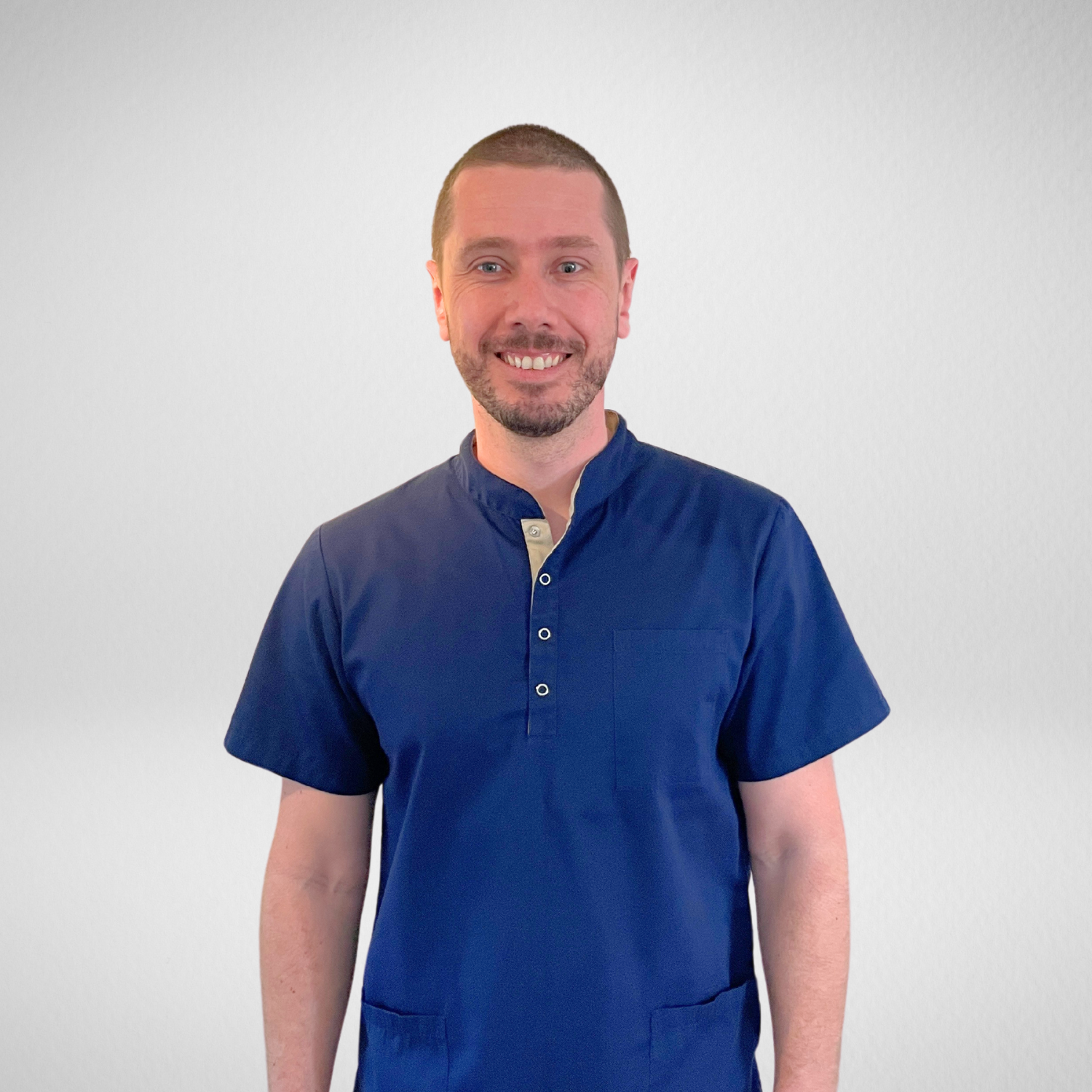 Tannlege Nenad Stojanovic i blå skjorte smiler til kameraet