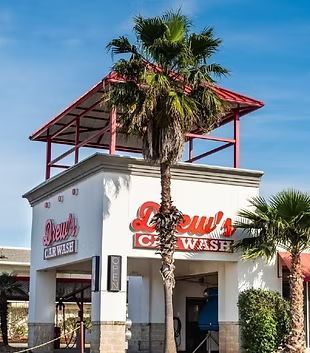 A car wash with a palm tree in front of it
