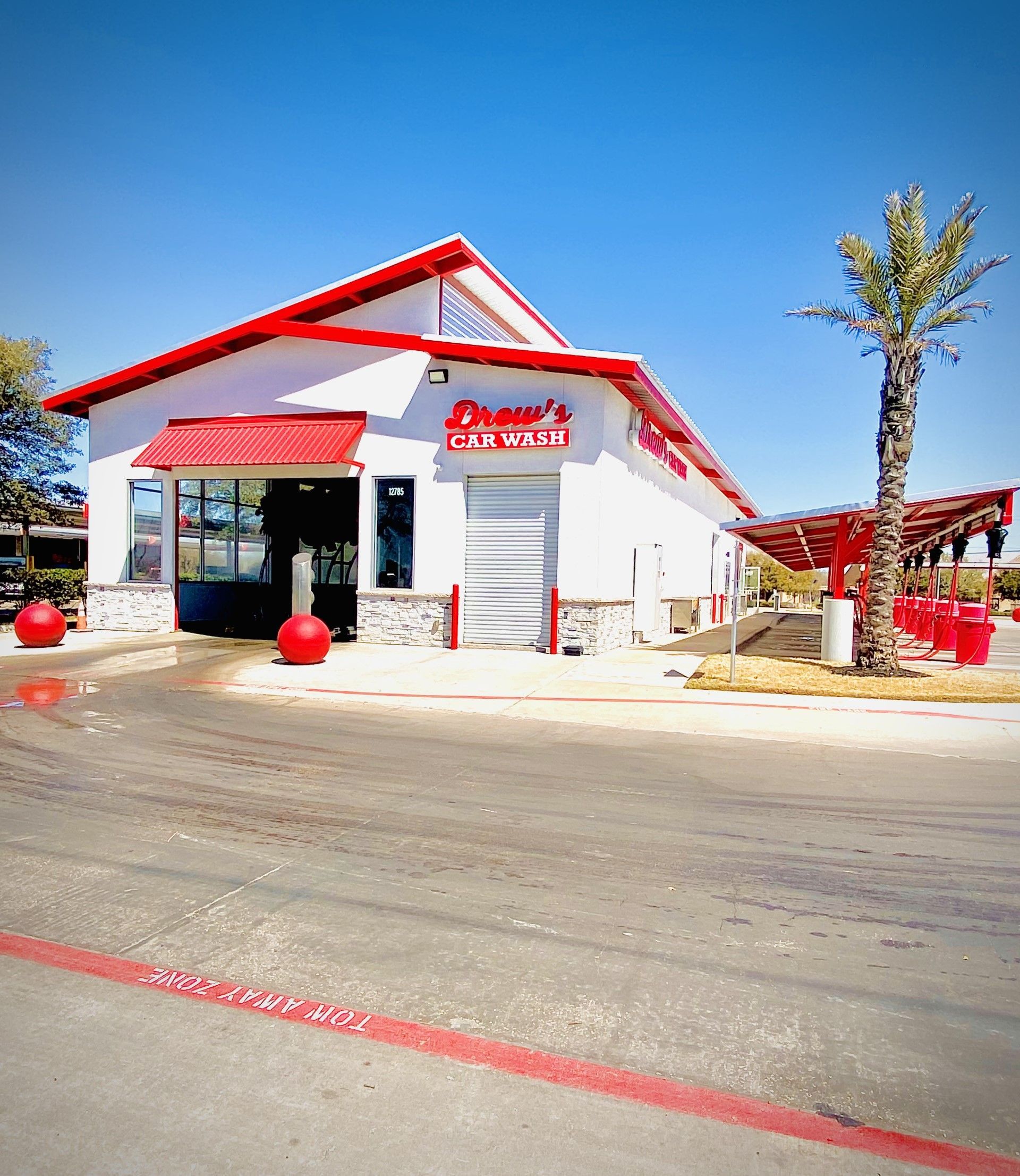 A white building with a red awning that says ' johnson 's car wash ' on it