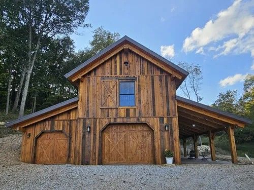 A large wooden barn with two garage doors and a porch.