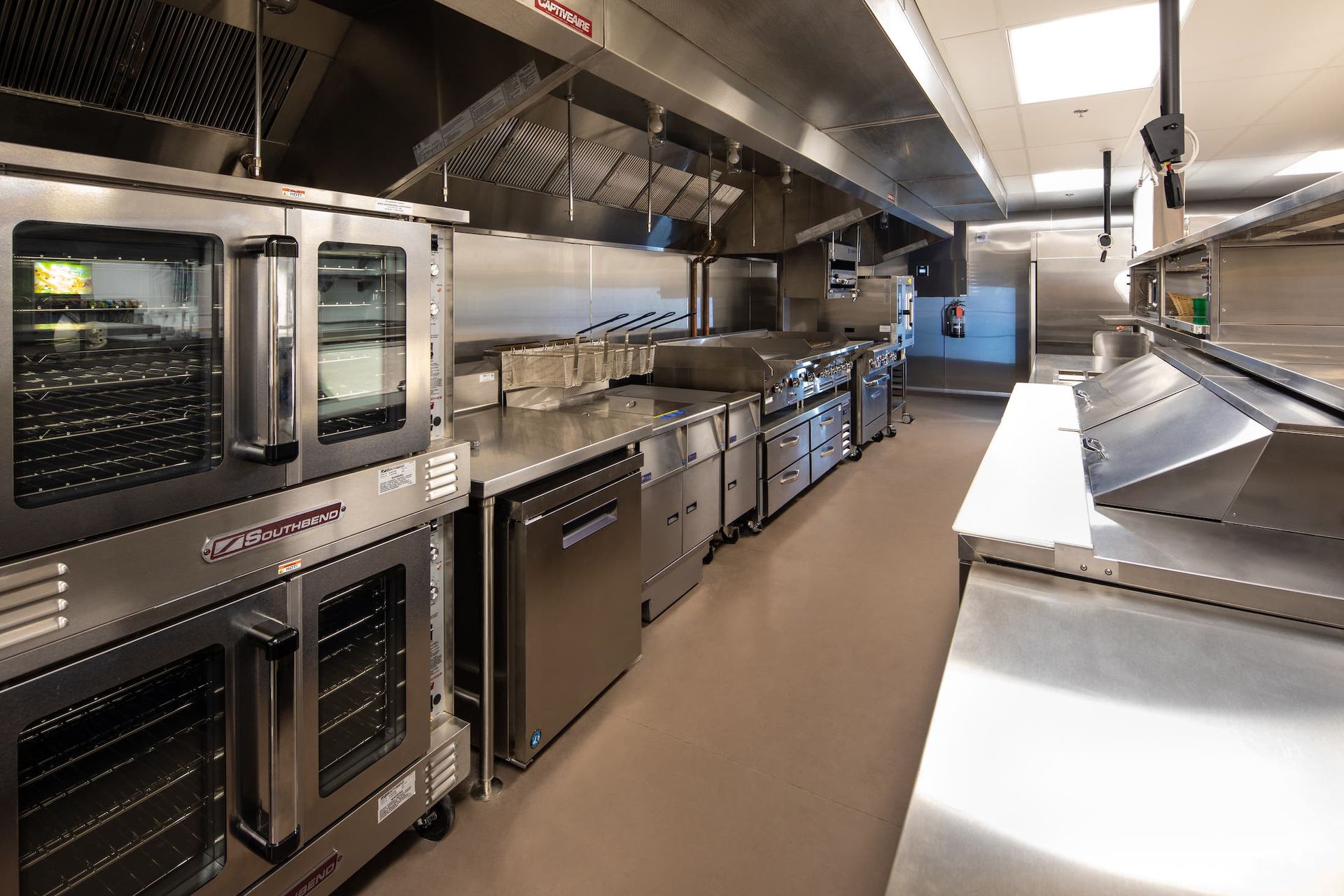 A long kitchen with a lot of stainless steel appliances