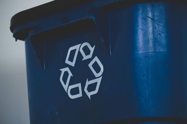 A close up of a recycling bin showing the familiar triangular arrow logo