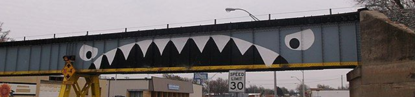 An overpass in Enid OK that's been painted to look like the open maw of a shark devouring the drivers that pass beneath it.