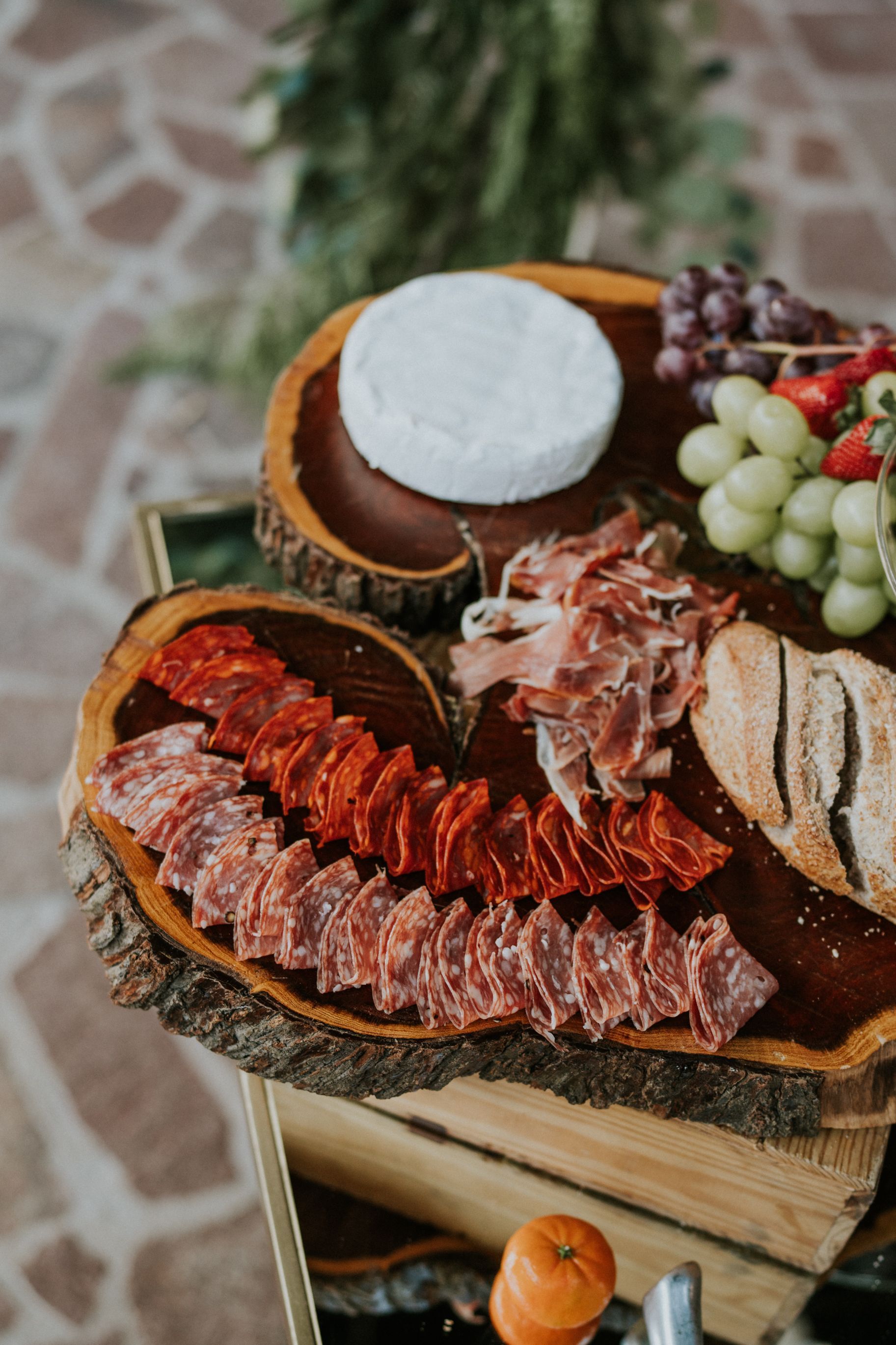 Rustic charcuterie board with cured meats, cheeses, grapes, and bread on a wooden table