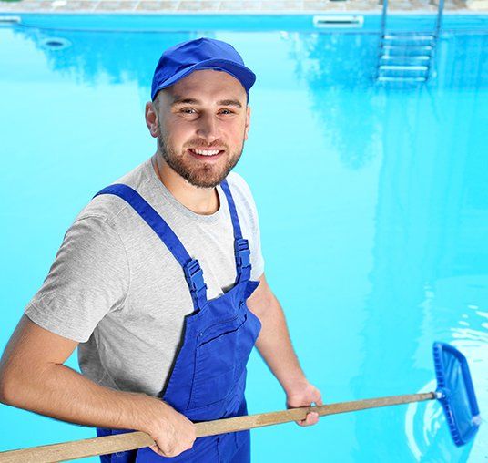 Male Worker Cleaning Outdoor Pool With Scoop Net