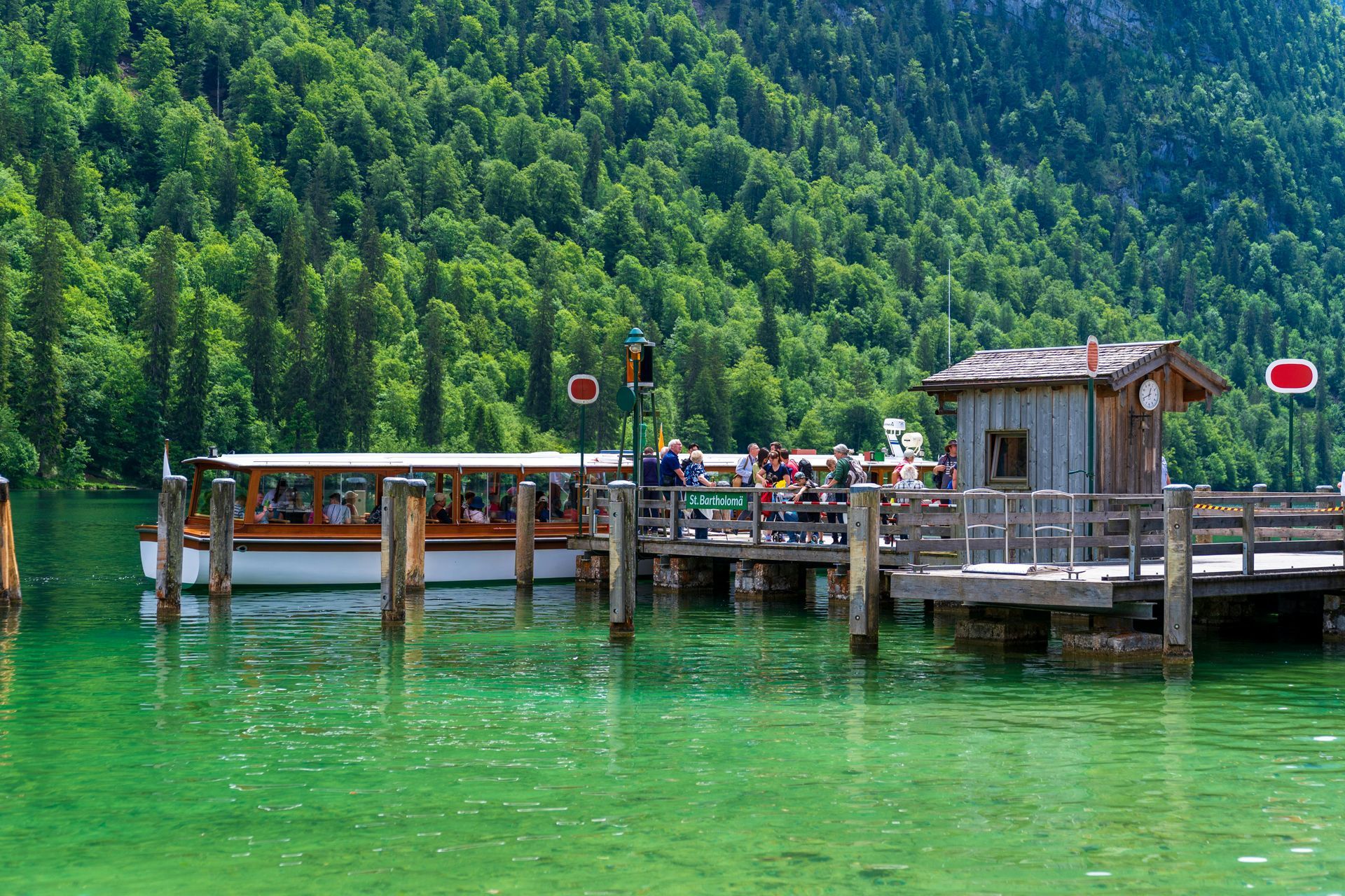 a man is picking up trash on the side of the road in front of a garbage truck .