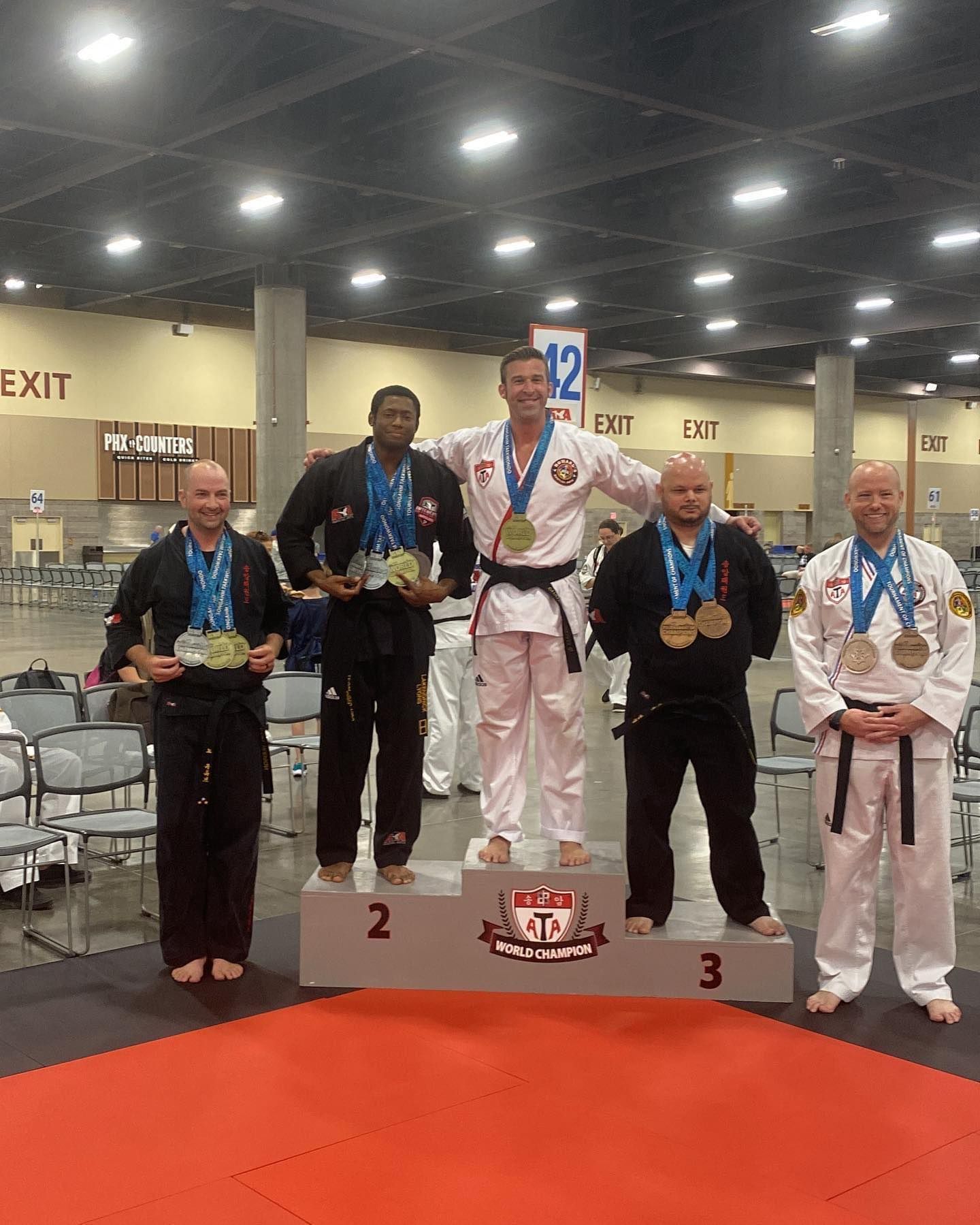 A group of men are standing on a podium with medals around their necks.