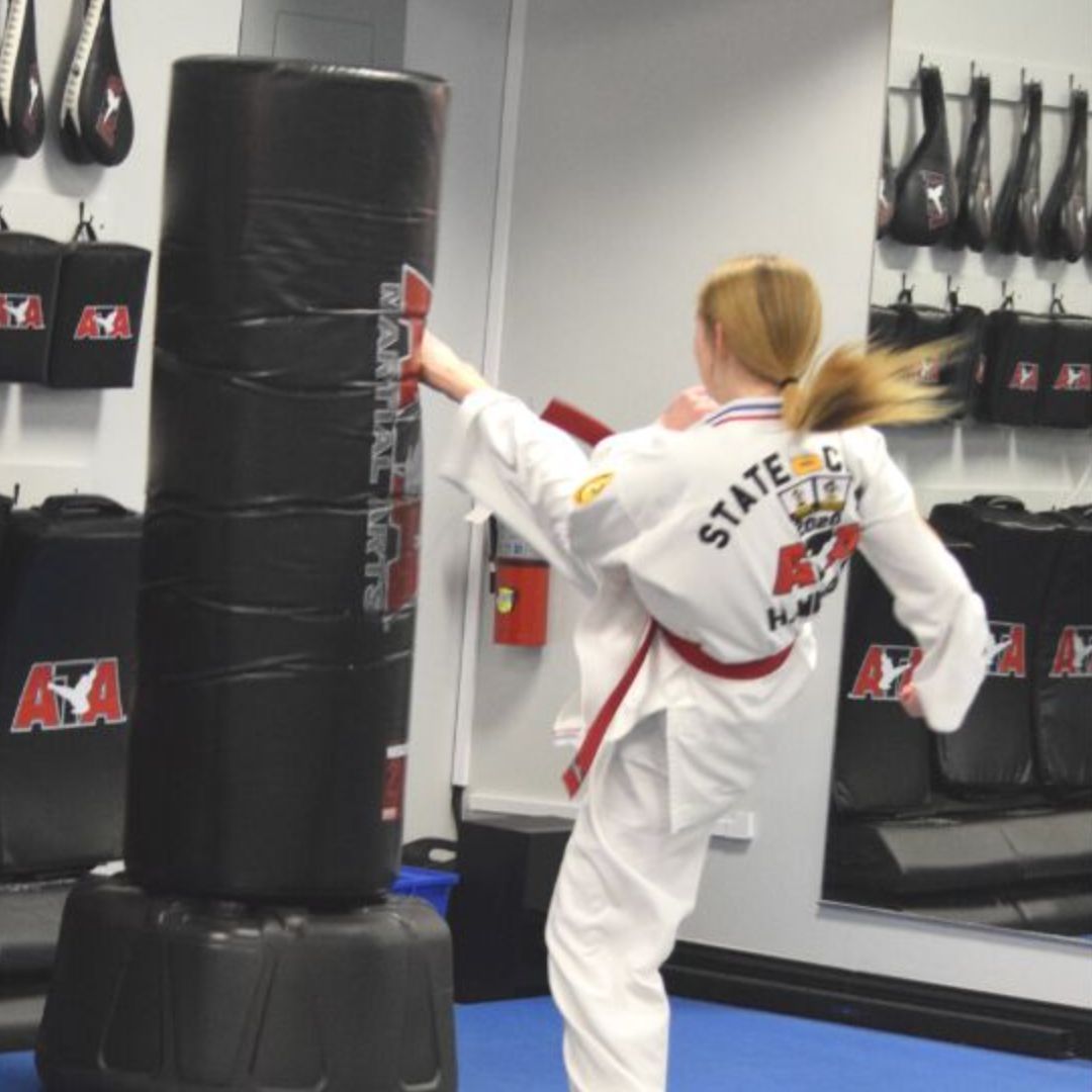 female kicking a punching bag