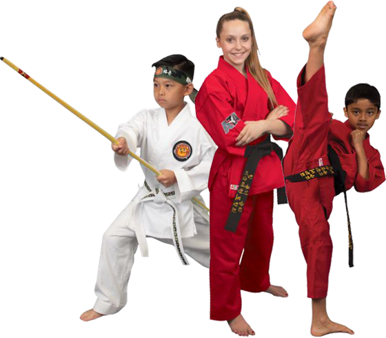 A woman in a red karate uniform is standing next to two children