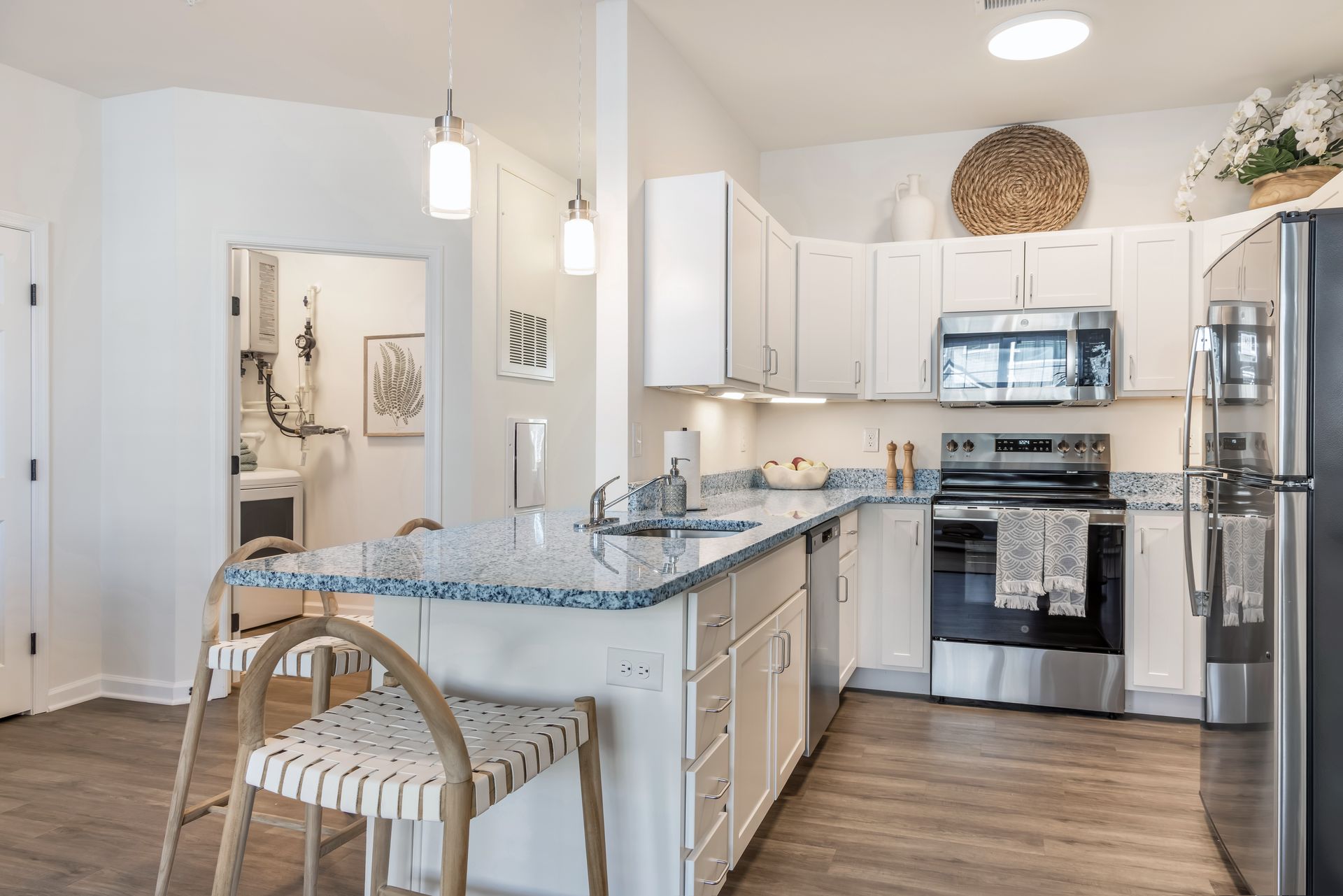 Modern kitchen with white cabinets, granite countertops, and stainless steel appliances.