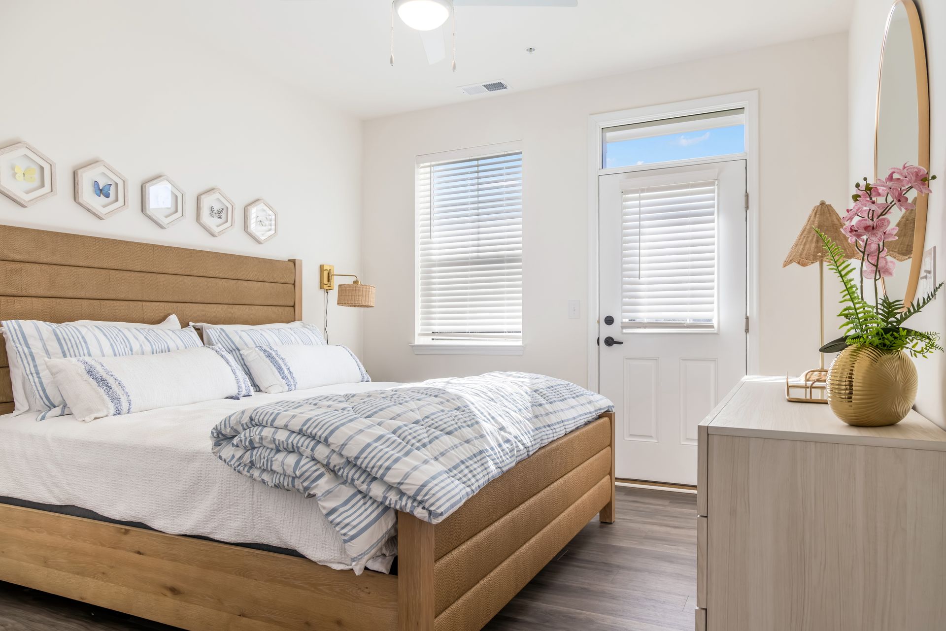 Bedroom with wooden bed, white bedding, window, and dresser.