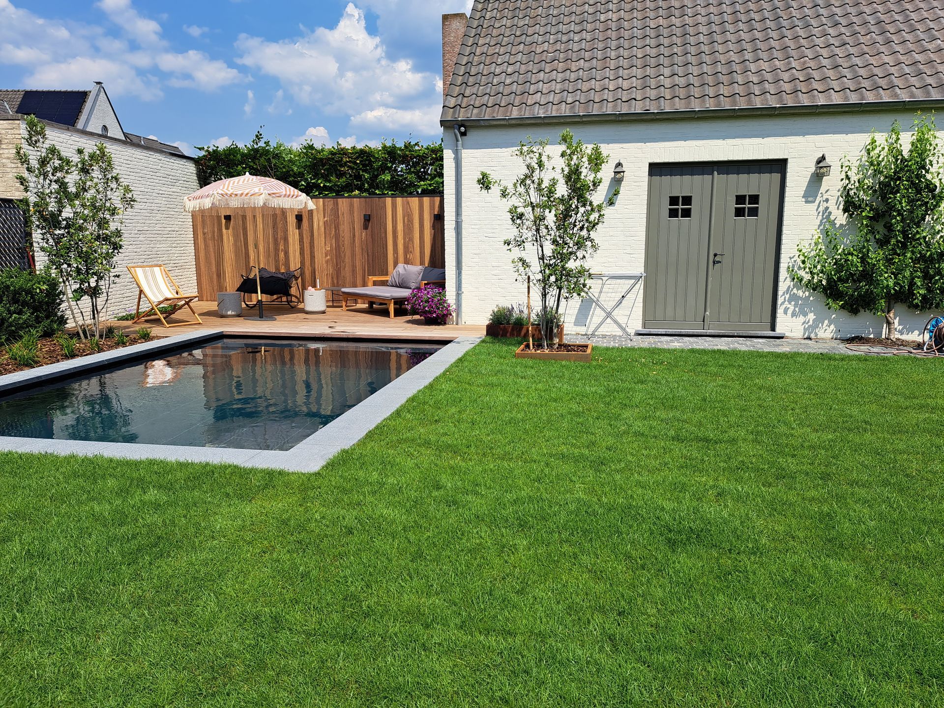 Er is een groot zwembad in de achtertuin van een huis.