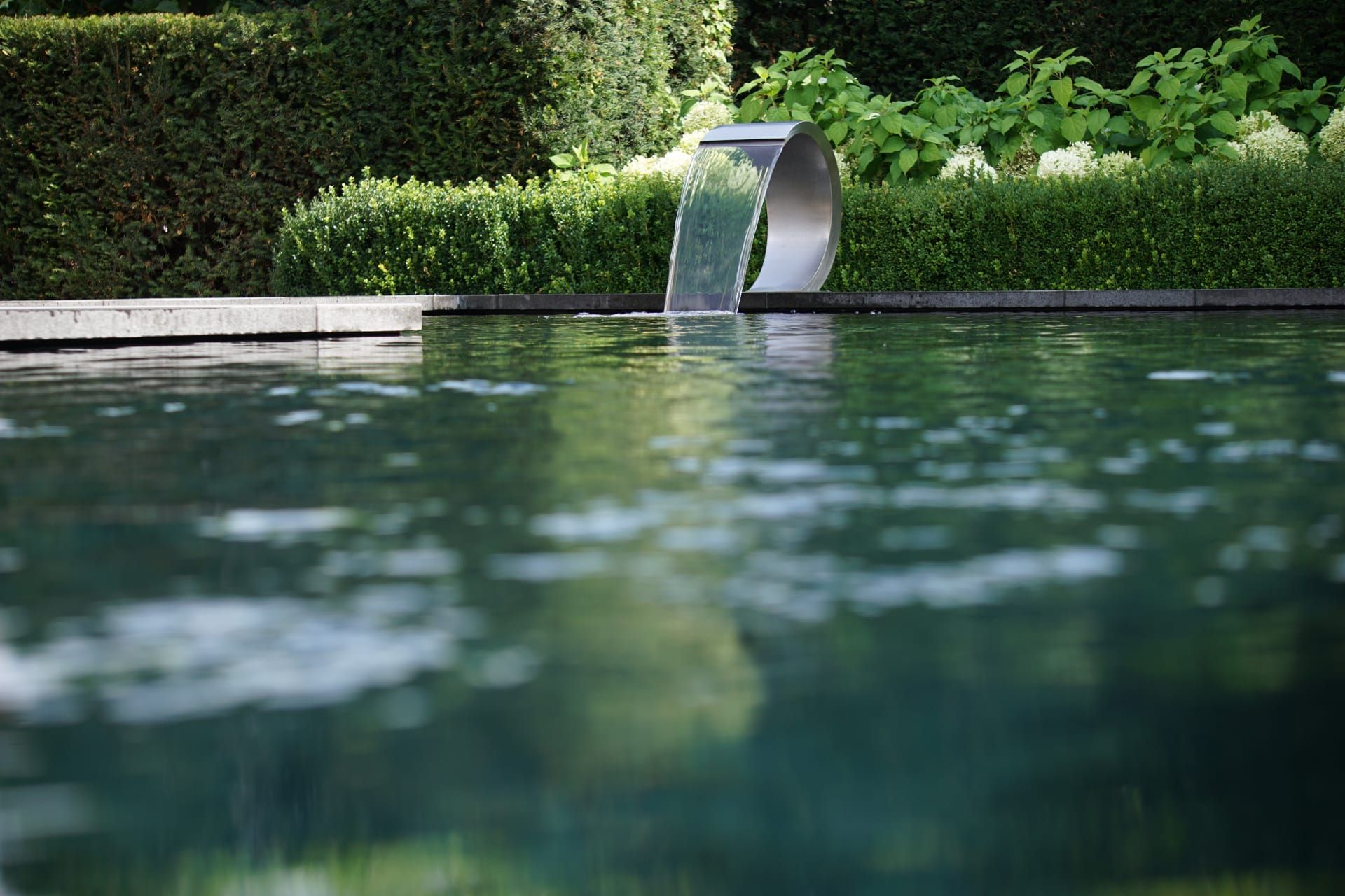 Een zwembad met een waterval in het midden, Bio pools & gardens