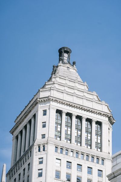 White stone skyscraper against a bright blue sky.