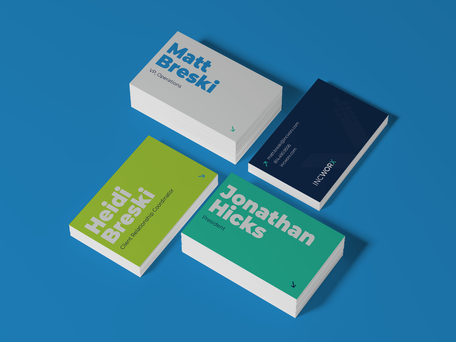 Stacks of business cards in different colors: blue, green, and white, with names printed on them.