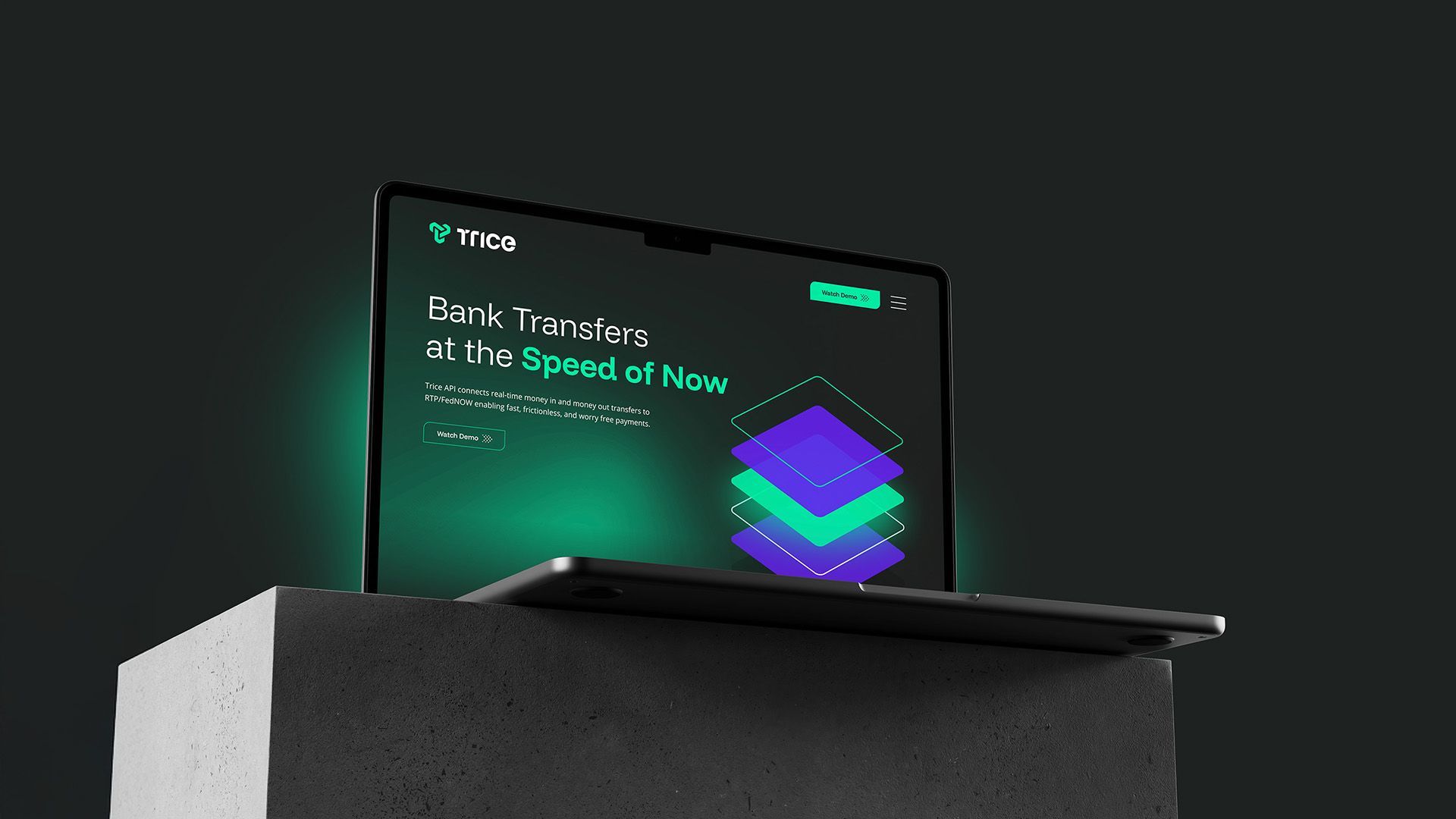 Laptop on a gray block, screen displaying a website with green and purple stacked shapes, dark background.