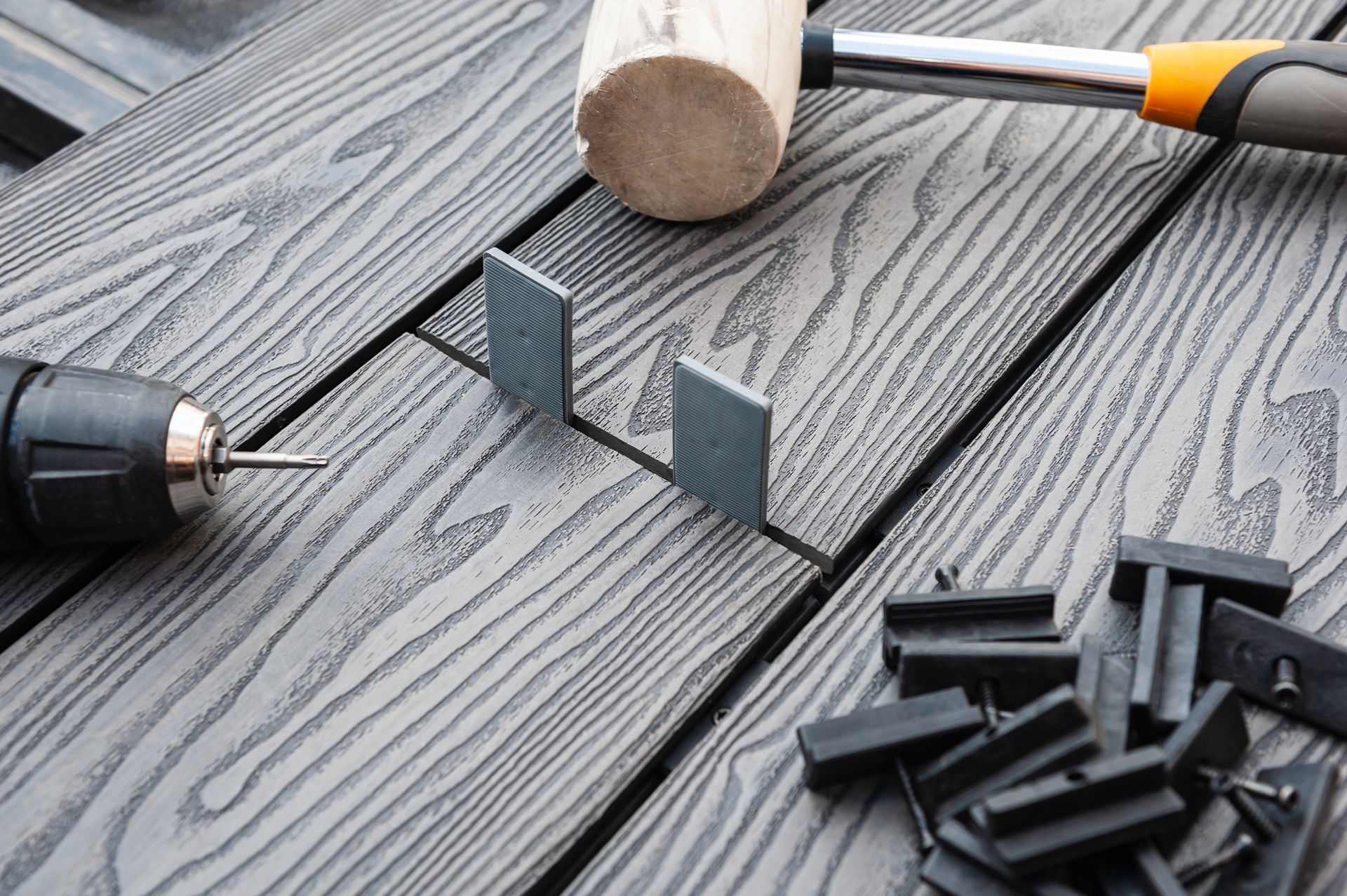 A hammer and drill are sitting on top of a wooden table.