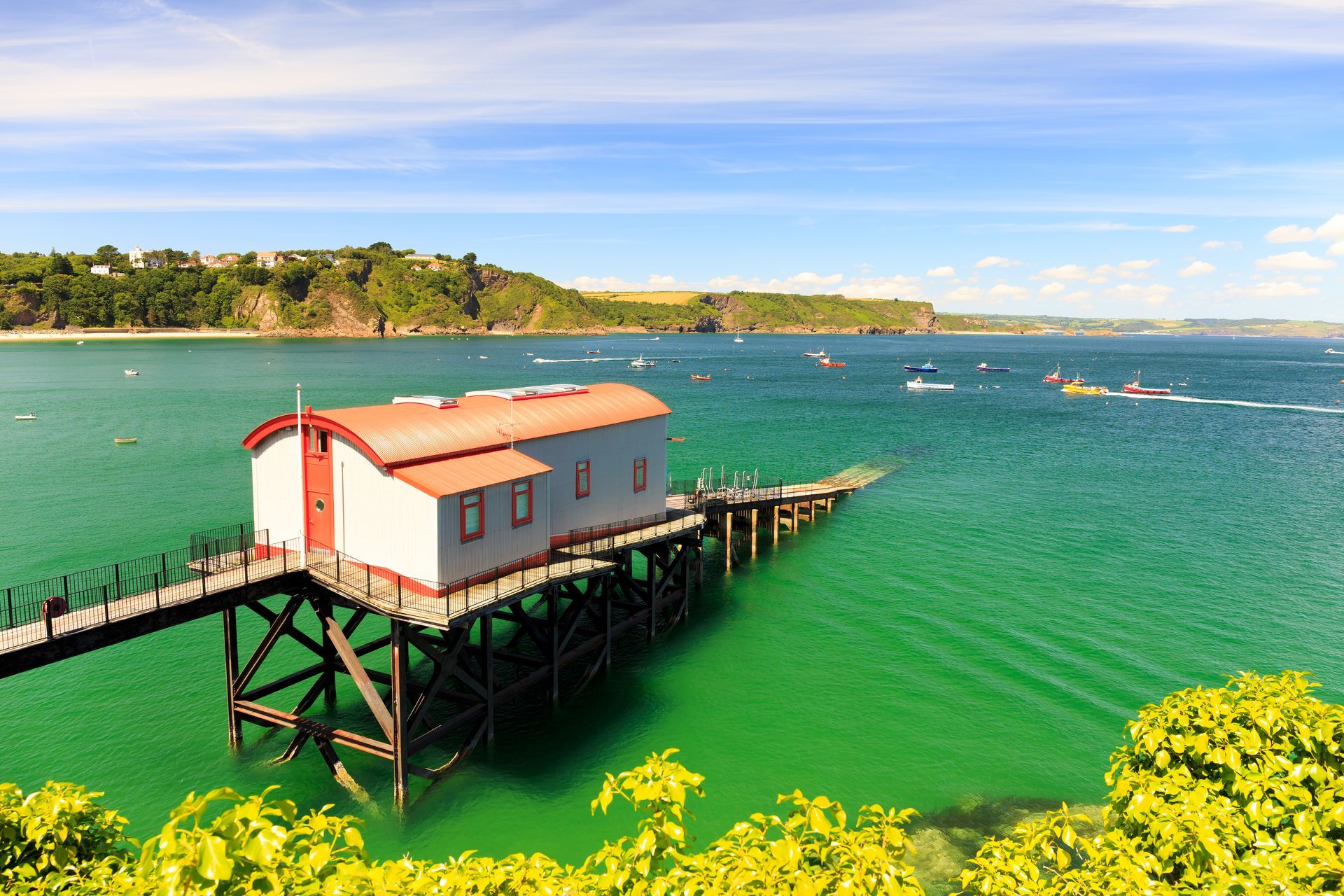A small building on a pier in the middle of a body of water.