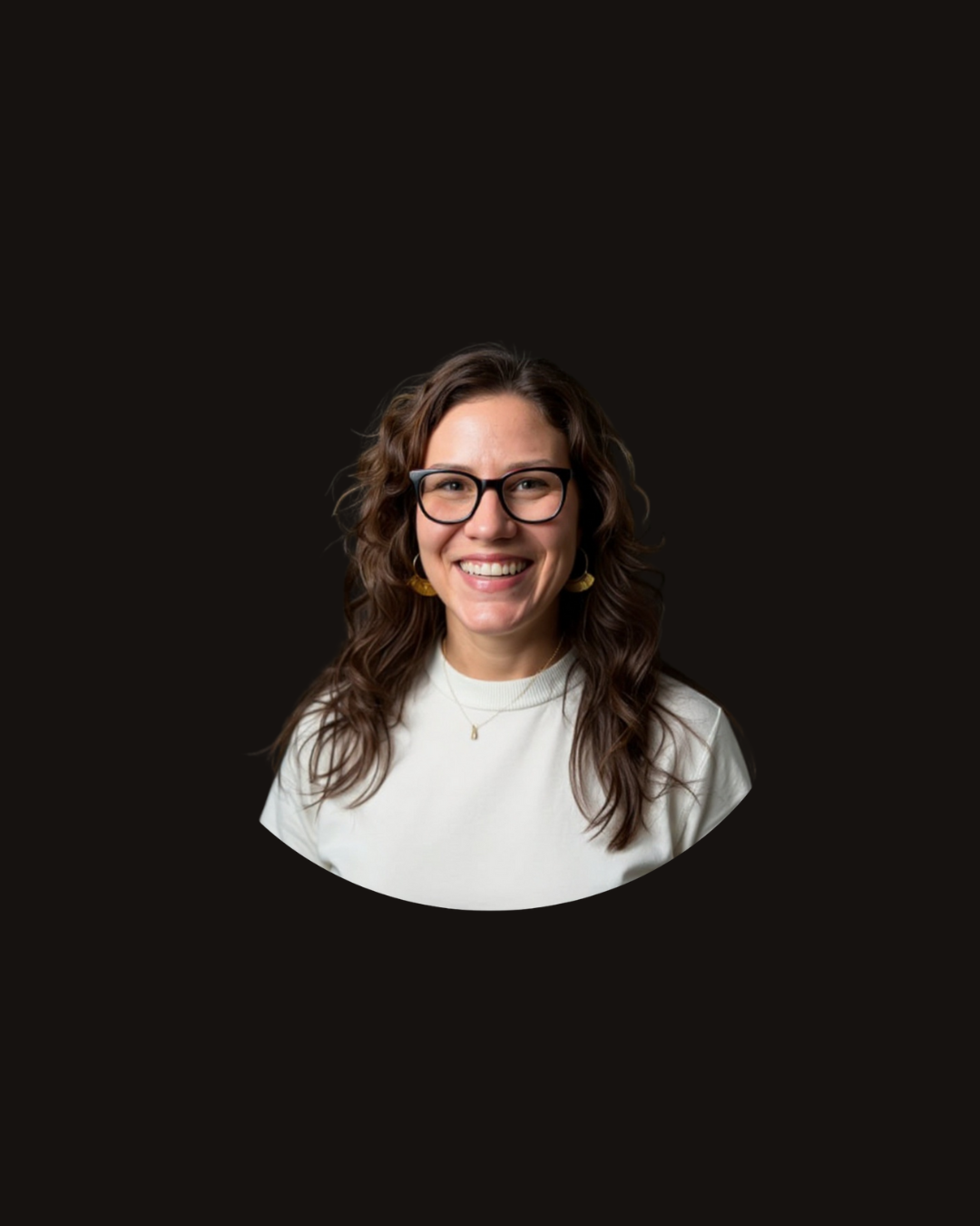 Woman with glasses smiles; wearing a white shirt against a dark background.