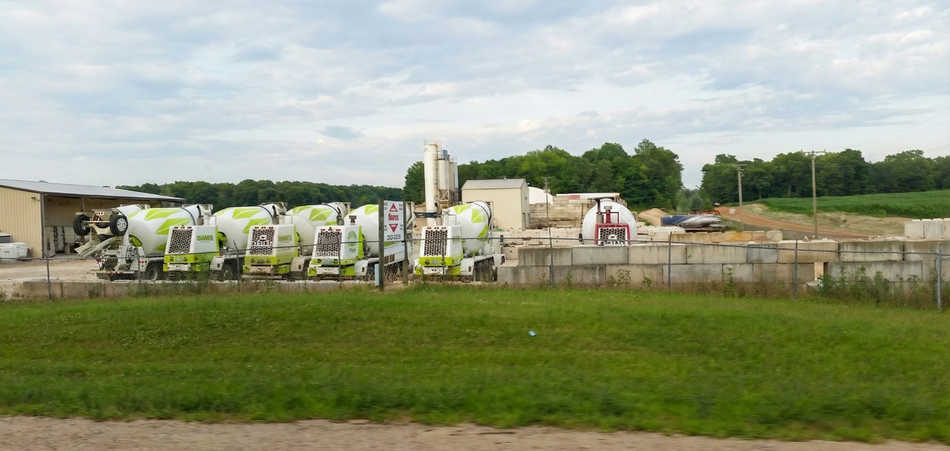 A green crane truck carrying concrete blocks.