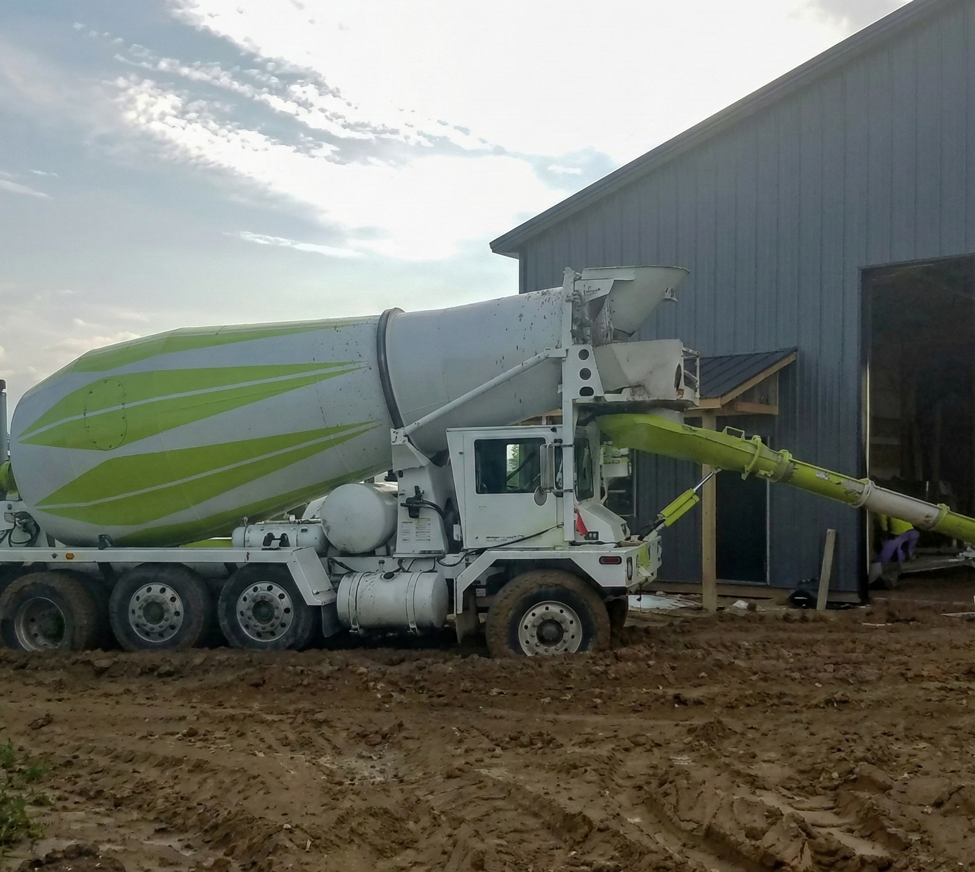 Concrete truck pouring cement onto a construction site.