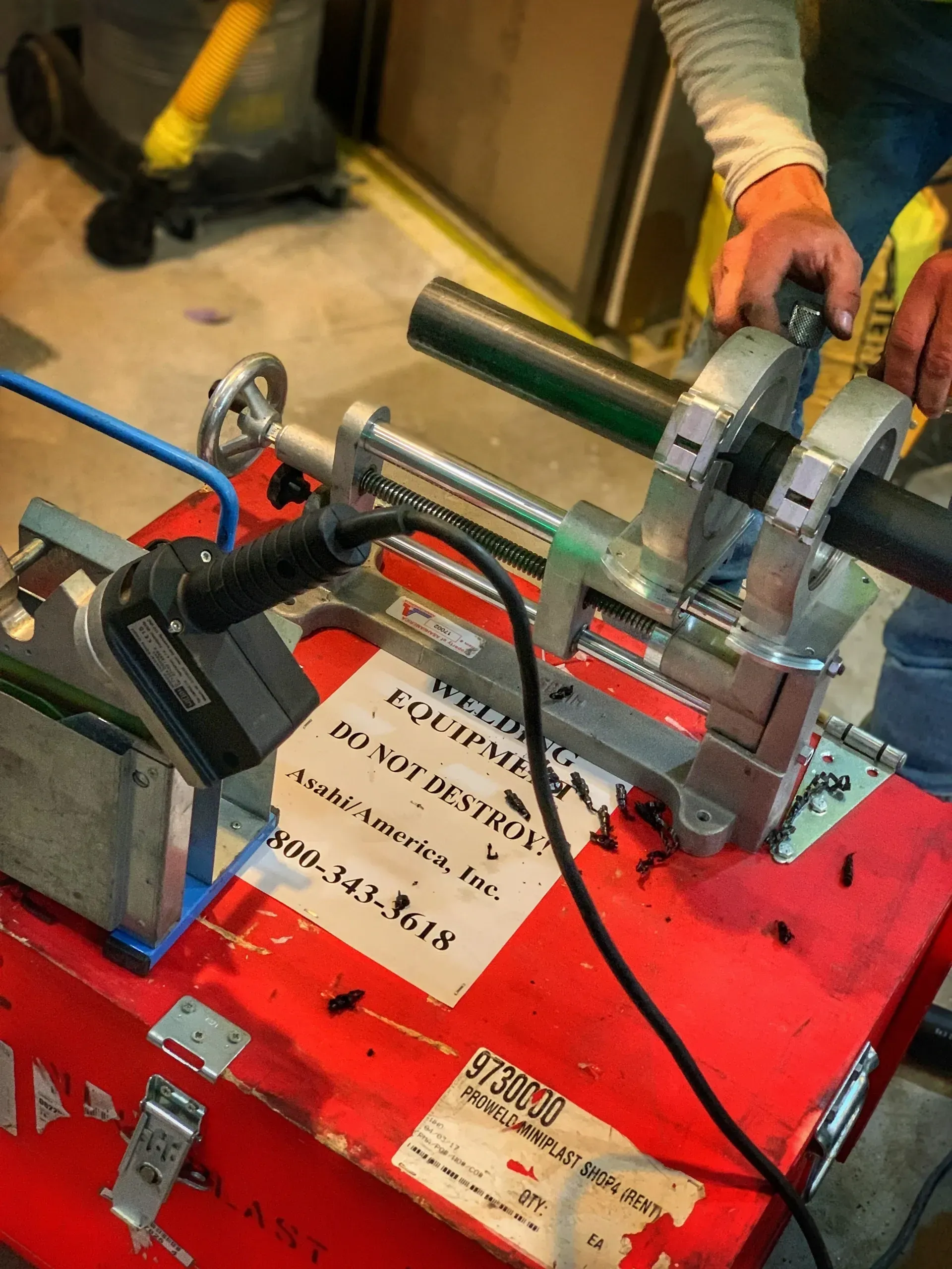 A person is using a machine on a red box.