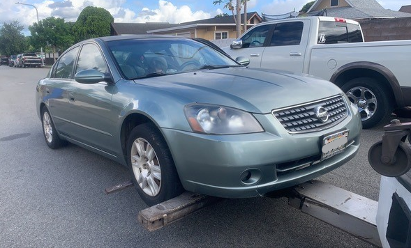 Towed Green Sedan- Maui Auto Recycling in Puunene, HI