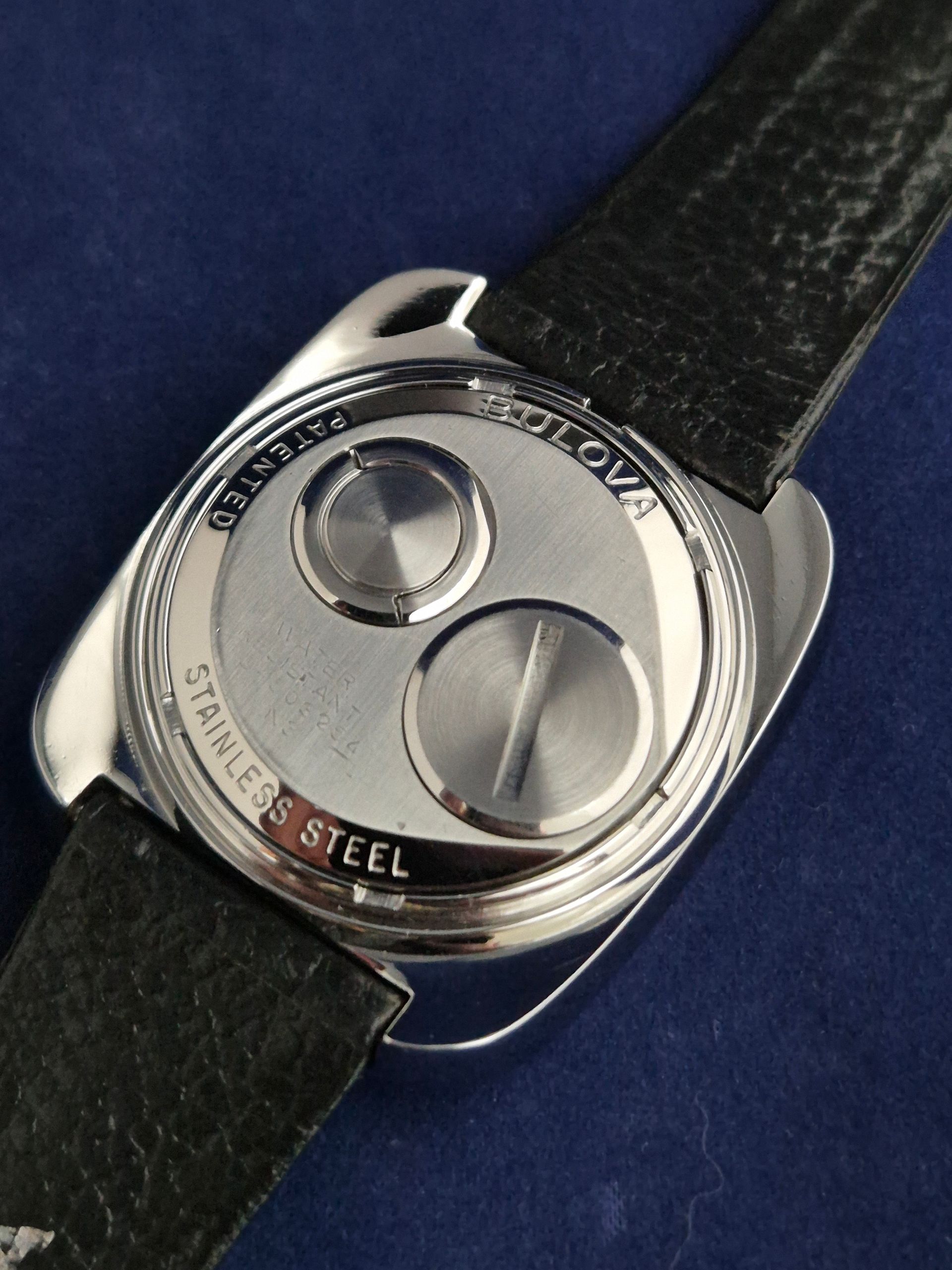 Back of a Bulova watch with a stainless steel case and black leather strap.