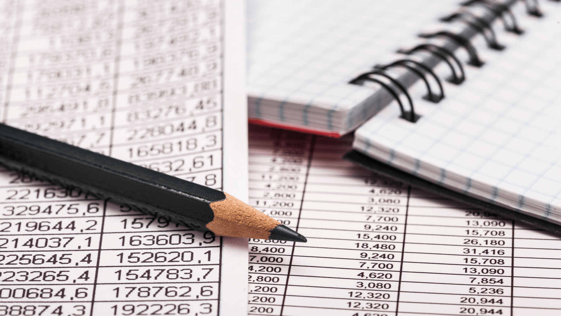 A pencil is sitting on top of a notebook with numbers on it.