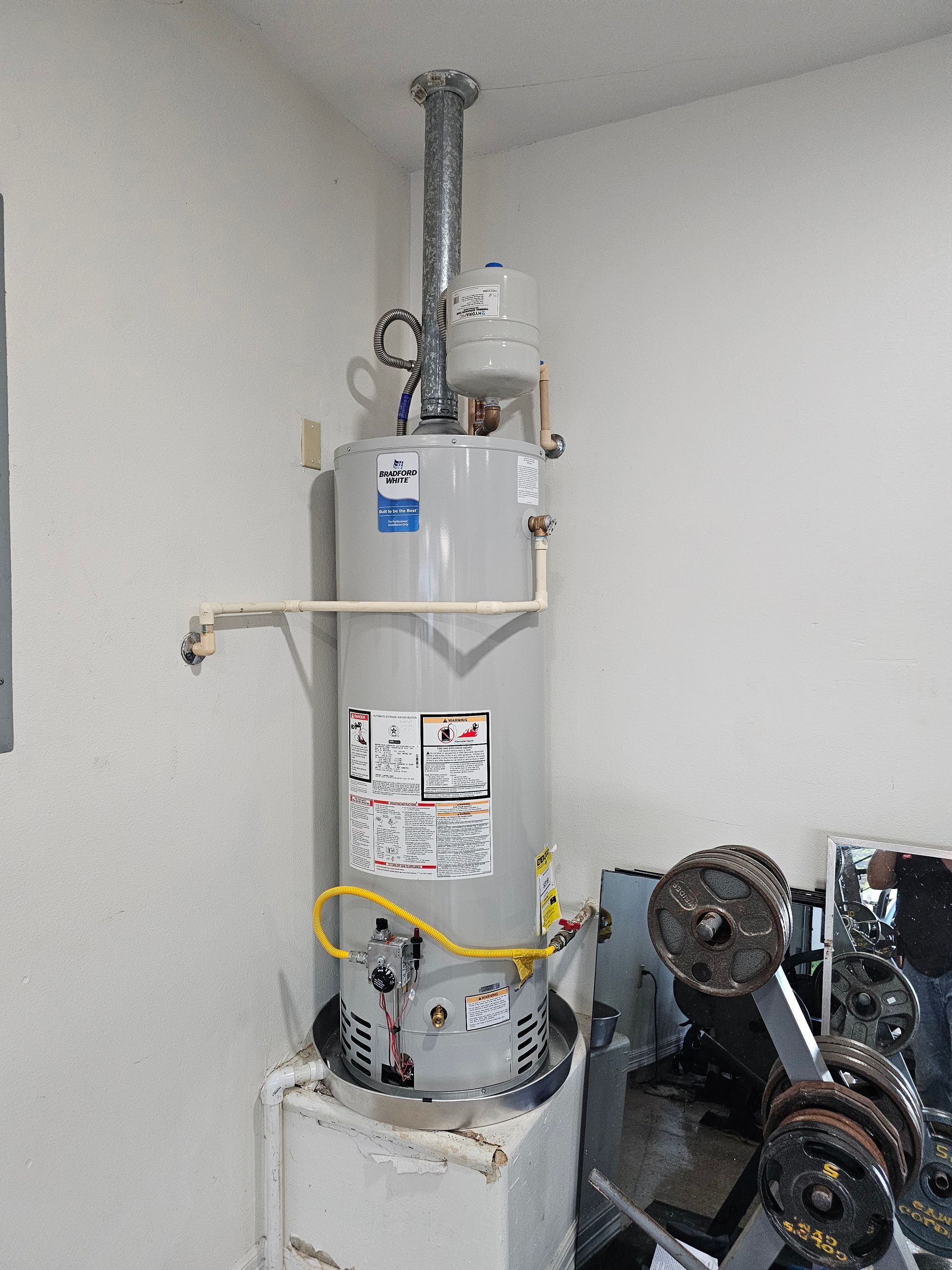 a gas water heater is sitting on top of a washing machine