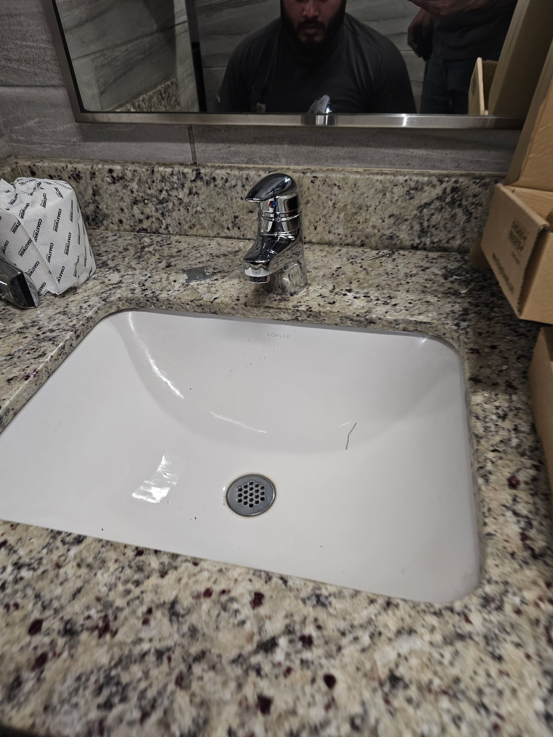 a man is taking a picture of himself in a bathroom sink